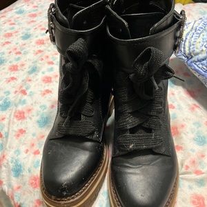 Black boots with brown bottom and strap with silver